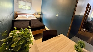 A compact room with a bed, a small table, and a potted plant. - WONDER HOSTAL - Santa Maria (Mexico City)