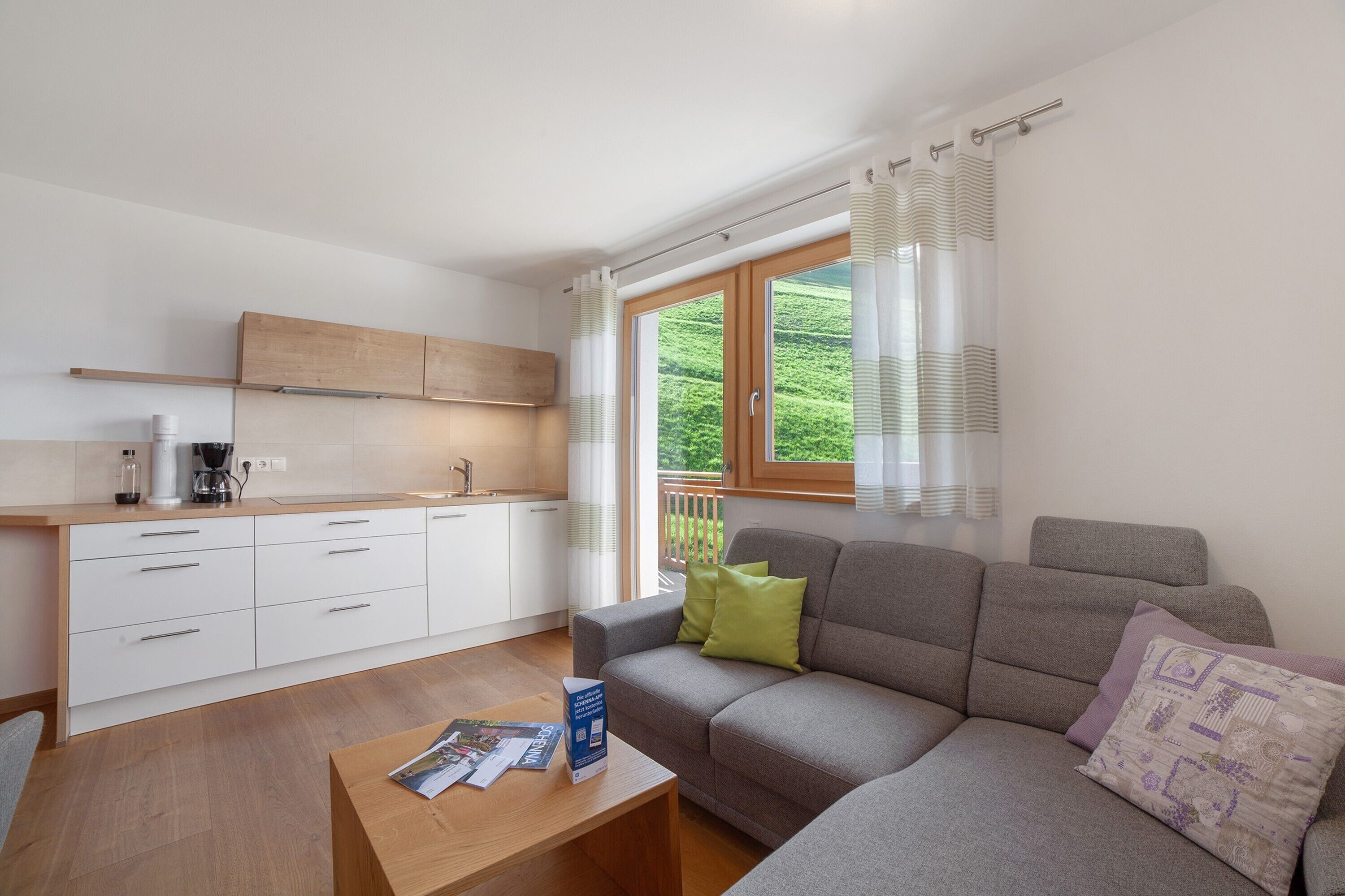 Ein modernes Wohnzimmer mit einer Couch, einem Couchtisch und Blick auf einen Balkon.