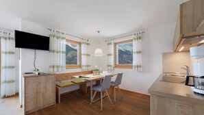 A modern kitchen with wooden cabinets, a built-in stove, and a window overlooking a mountainous landscape. - Apartment 'Thymian' with Mountain View, Private Terrace and Wi-Fi (Schenna)
