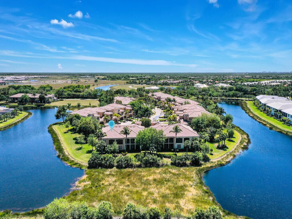 A large, multi-story building surrounded by water and greenery, with a clear view of the surrounding landscape.