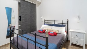 Une chambre à coucher comprenant un lit, une table de chevet, une armoire et un miroir.