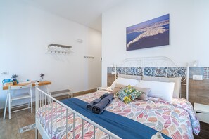 A bedroom with a bed, a desk, and a chair.