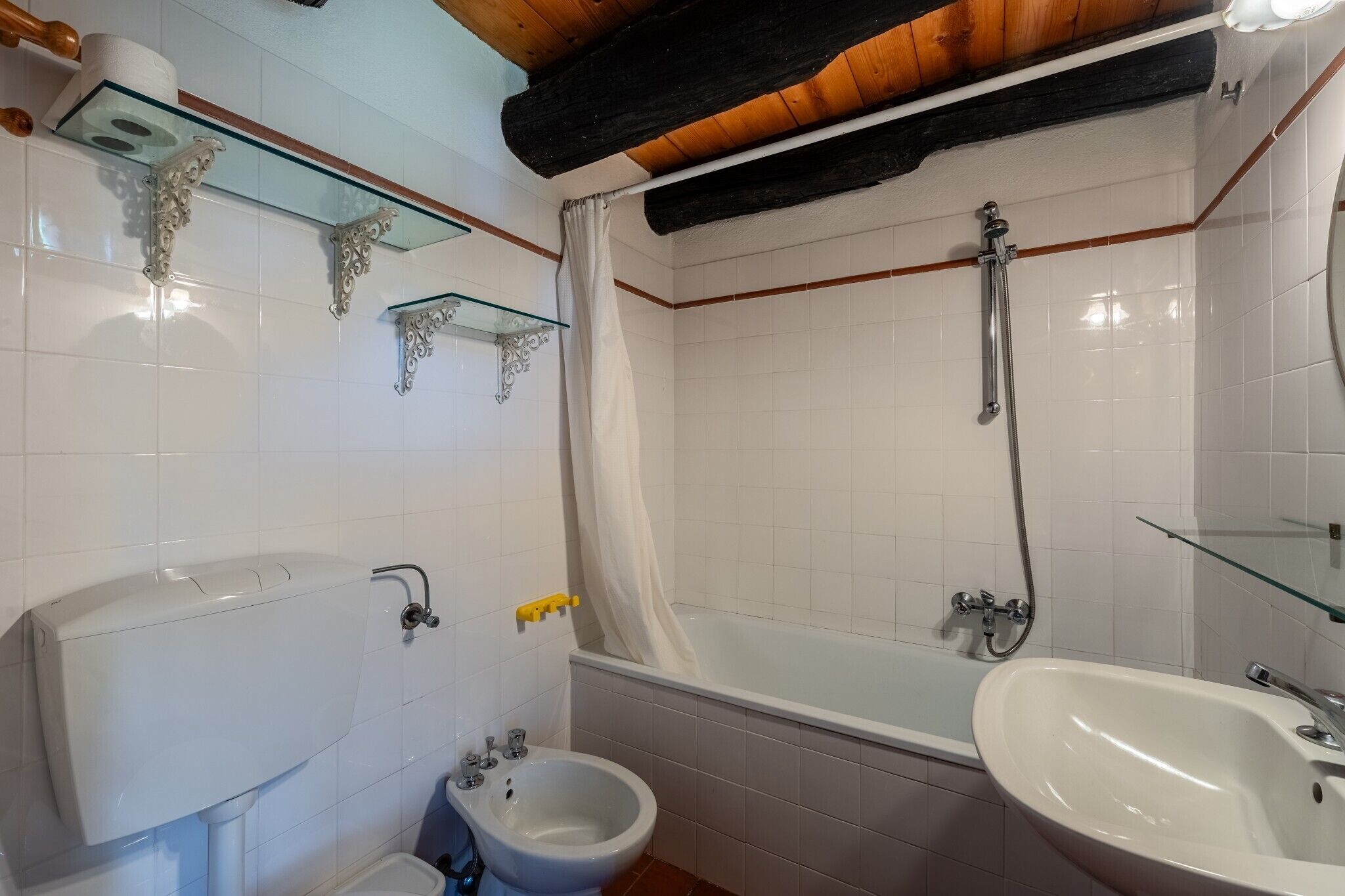 A bathroom with a toilet, bidet, bathtub, and a sink.