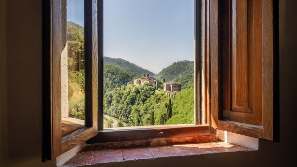 A window with a view of a mountainous landscape and a building. - Apartment 'Casa Di Gigi' with Mountain View, Shared Pool and Wi-Fi (Pietrabuona)