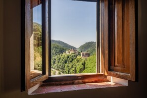 Une fenêtre donnant sur un paysage montagneux et un bâtiment.