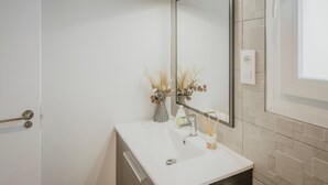 A bathroom with a white sink, mirror, and towel rack. - Holiday Home 'La Isi' with Private Garden and Wi-Fi (Rades de Abajo)