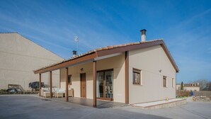 A modern house with a covered patio, a garage, and a large open driveway. - Holiday Home 'La Isi' with Private Garden and Wi-Fi (Rades de Abajo)