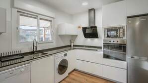 A modern kitchen with a built-in washing machine, oven, and refrigerator.