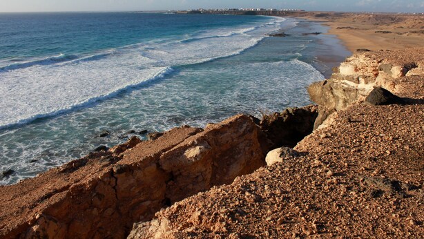 A coastal landscape with rocky terrain and a beach. - Vacation Home 'Bianco' with Shared Terrace and Wi-Fi (El Cotillo)