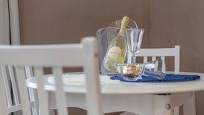 A table with a bottle of Prosecco wine, a glass, and a small bowl. - Vacation Home 'Bianco' with Shared Terrace and Wi-Fi (El Cotillo)