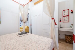 Een slaapkamer met een bed, een bureau en een kledingkast.