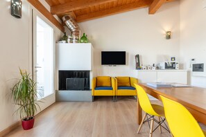 Un salon moderne avec un canapé, une table à manger et un téléviseur.