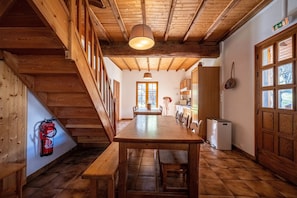 Un intérieur en bois comprenant une table à manger, des bancs, un escalier et un extincteur.