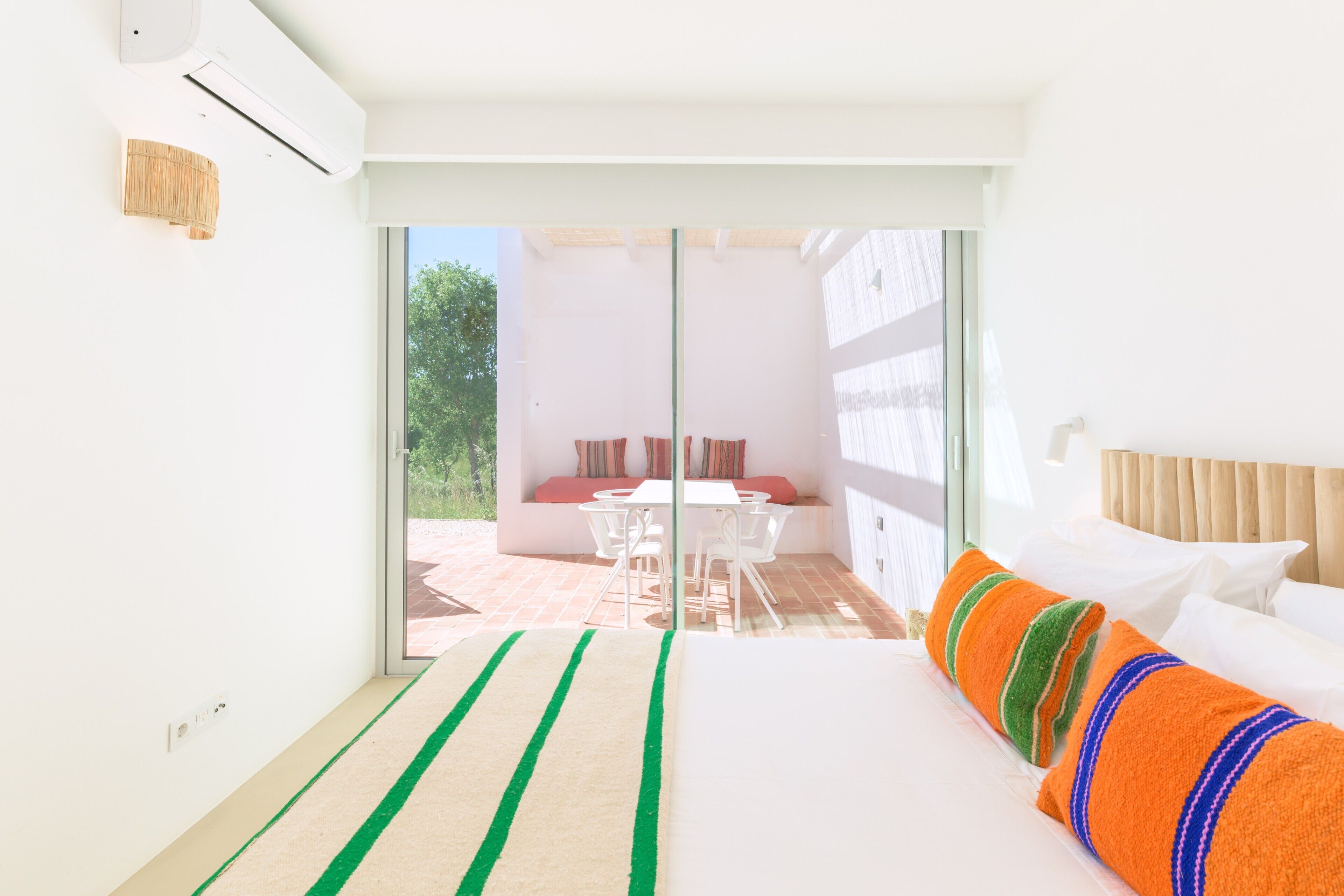 Una habitación de hotel con cama, ventana y vista a un área de estar exterior.