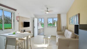 A modern living room with a sofa, a dining table, and a TV. - 'Vista' with Shared Pool, Wi-Fi and Air Conditioning (Maspalomas)