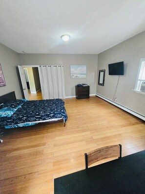 A bedroom with a bed, a desk, a chair, a TV, and a window. - Nice spacious room near Whole Foods, Brown Univer. (Providence)