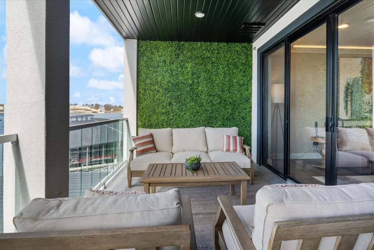 A balcony with a green wall, a sofa, and a coffee table.