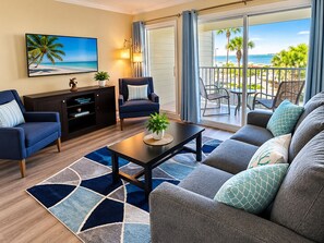 A living room with a sofa, armchairs, a coffee table, and a television. - Cozy, Remodeled Retreat with Stunning Sunset Views Complete with Heated Pool! (Tampa)