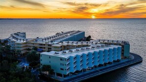 Et kysthotel med lystbådehavn, flere parkeringsniveauer og udsigt til solnedgang.