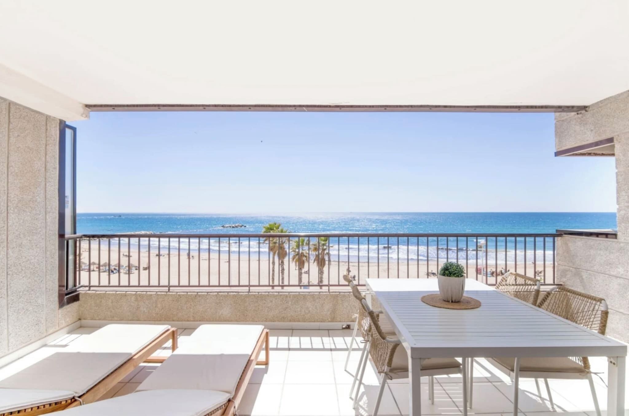 Ein Balkon mit Blick auf Strand und Meer.