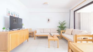 A modern living room with a sofa, coffee table, and TV on a wooden cabinet. - Calpe Playa | Arenal Bol Calpe (Calpe)
