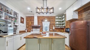 A modern kitchen with white cabinetry, a wooden island, and a vintage Philco refrigerator. - 1800s Farmhouse—King Bed~Big Kitchen~Games & DVDs (Broken Arrow)