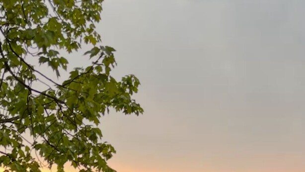Eine Holzsteganlage mit zwei Stühlen, die auf einen stillen See bei Sonnenuntergang blicken.