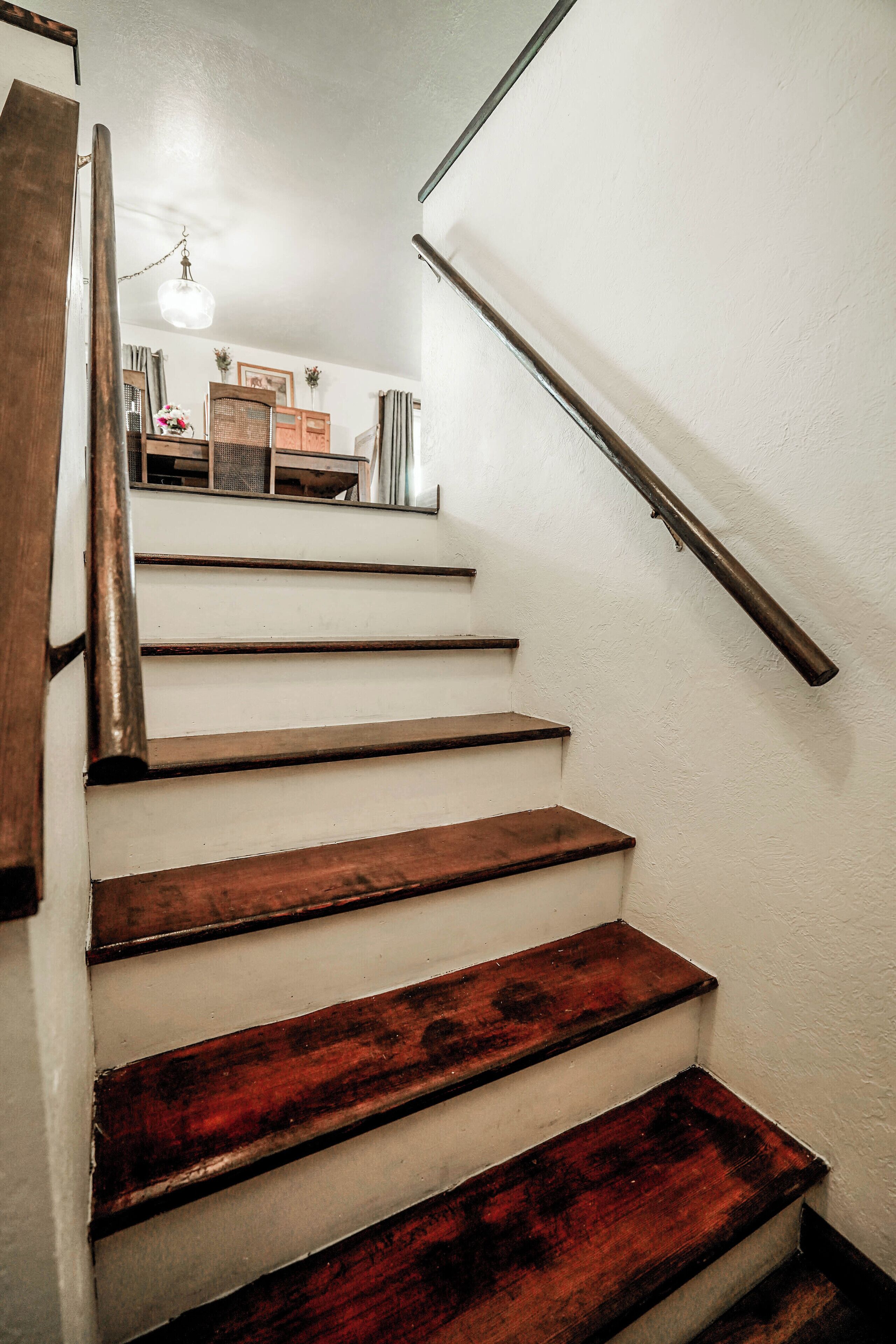 Una escalera de madera con barandilla de metal.