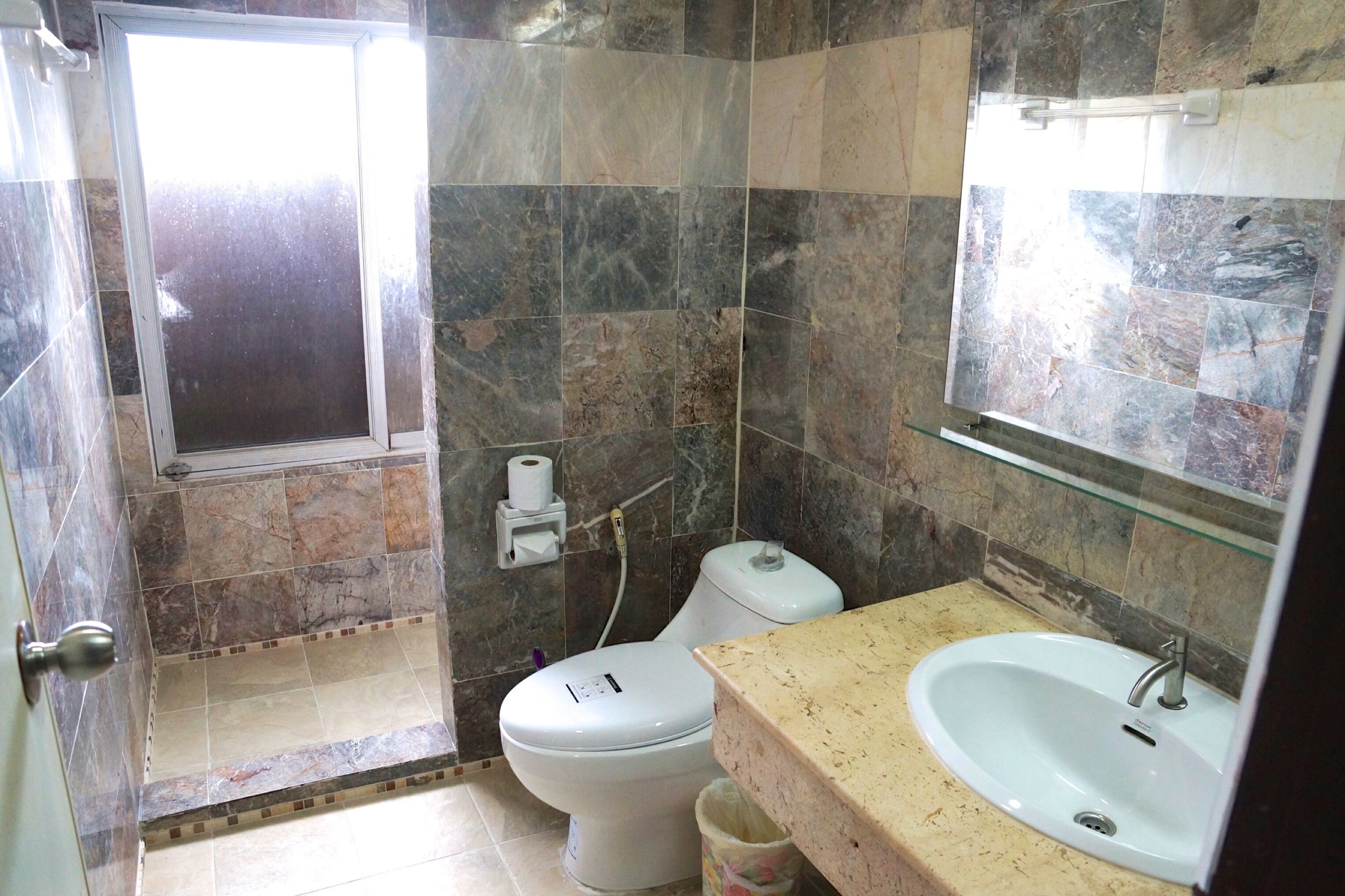 A bathroom with a shower, toilet, and sink.