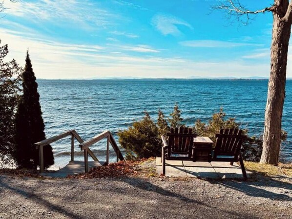 Un banco con vistas a un cuerpo de agua bajo un cielo despejado.