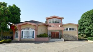 A two-story house with a front porch, a garage, and a driveway. - Shikra Tourist Resort (Dabwali)