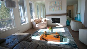 Un salon moderne avec une table basse en verre, des canapés en cuir et une cheminée.