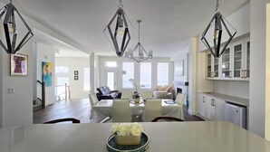 Un espace repas moderne avec une table blanche, des chaises et un arrangement floral blanc en guise de décoration centrale.