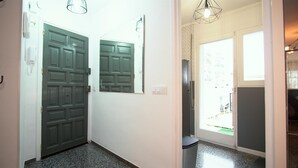A hallway with two doors, a light fixture, and a window.