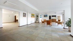 A spacious room with a tiled floor, a dining area with chairs, and a potted plant. - Apartment 'Torralta' with Sea View, Wi-Fi and Air Conditioning (Alvor)