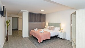 A modern bedroom with a bed, bedside tables, and a wall-mounted TV. - GuestReady - Flat near the Marina of Valencia (Valencia)