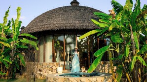A thatched-roof structure with a stone wall and a swimming pool. - Chongzuo Wild Stay Collection - Wanxiang (Chongzuo)