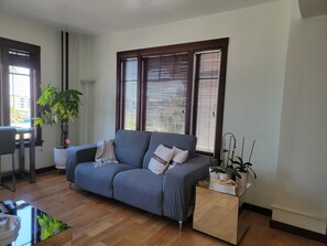 Relax in this serene living space with a comfortable sofa, coffee table, and potted plant.