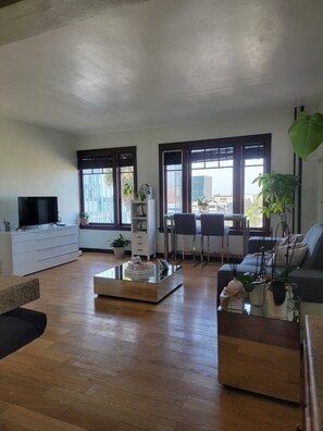 Relax in a spacious living room with a large TV, comfortable seating, and a dining area.
