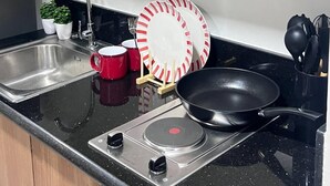 A kitchen with a stainless steel sink, a stove, and wooden cabinets. - 10th floor (Pasay)