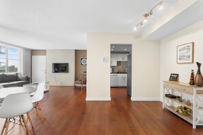 A spacious living area with a dining table, chairs, a sofa, and a kitchen in the background. - Bay Harbor Sunset Apt 5B (Bay Harbor Islands)