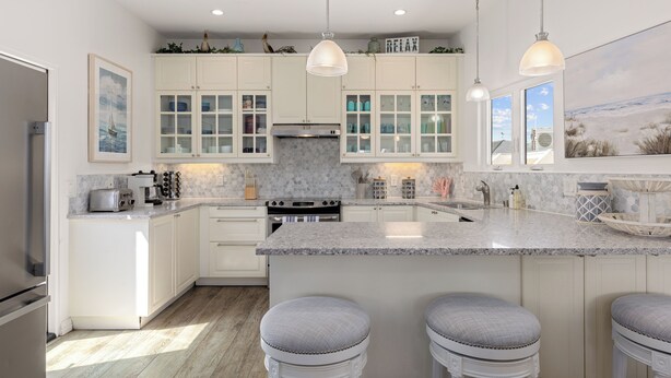 A modern kitchen with white cabinets, a granite countertop, and pendant lighting. - Single Family Retreat | Steps to Bay & Beach | Fireworks Views (San Diego)