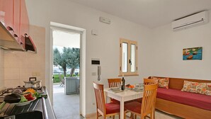 A modern kitchen with a dining area, a sofa, and a painting on the wall. - Stella Marina Apartment 6, Vieste, Italy (Vieste)