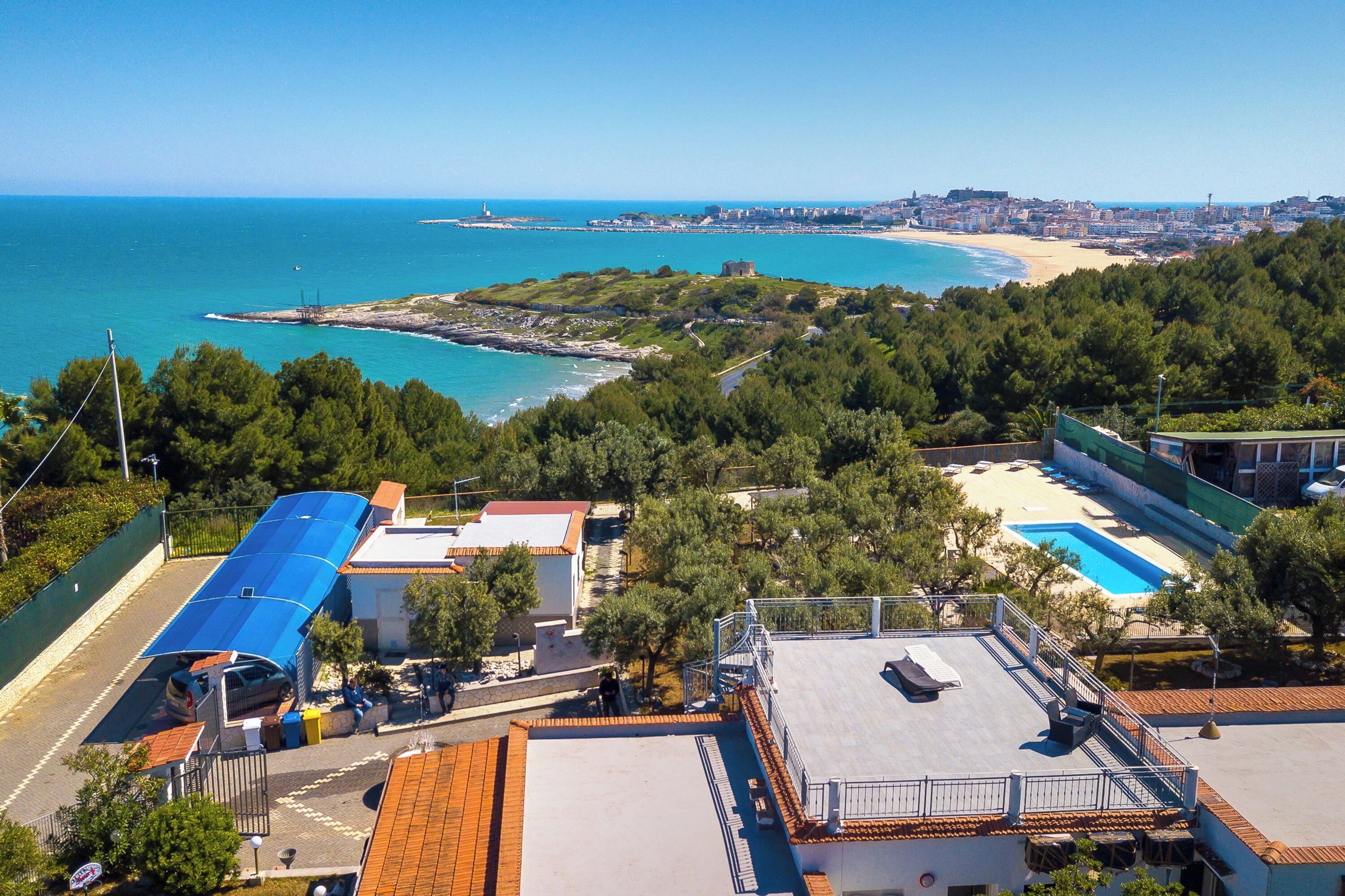 Un hôtel situé sur la côte, doté d’une piscine sur le toit, offrant une vue sur la plage et disposant d’un parking.