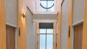 A hotel hallway with a patterned carpet, wooden paneling, and a skylight. - ZaoSunvalley Hotel (Yamagata)