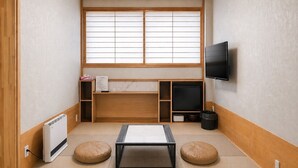 A room with tatami flooring, a tatami mat table, a heater, a television, and a window with shoji screens. - ZaoSunvalley Hotel (Yamagata)