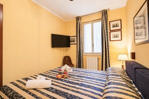 A hotel room with a bed, a flat-screen TV, a window with curtains, and framed pictures on the wall. - Alice Suite Terrace, lake view & Park, Gardone Riviera, Italy (Gardone Riviera)