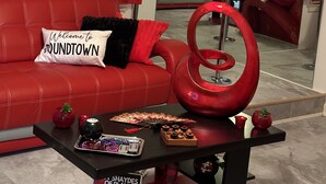 Un espacio de estar rojo con un sofá, una mesita de centro y un espejo.