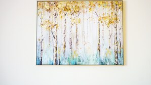 A painting of trees with yellow leaves on a white wall.