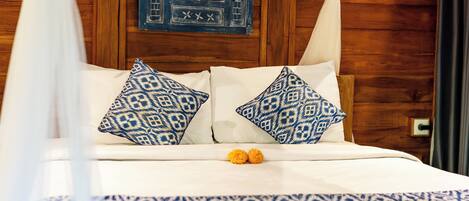Un lit à baldaquin, des coussins à motifs et un élément décoratif mural.